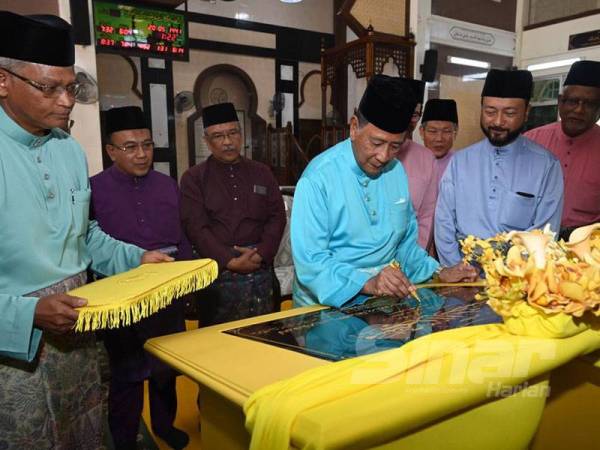 Sultan Sallehuddin menandatangani plak perasmian Masjid Al-Ihsan kariah Bukit Larek, Pokok Sena hari ini.