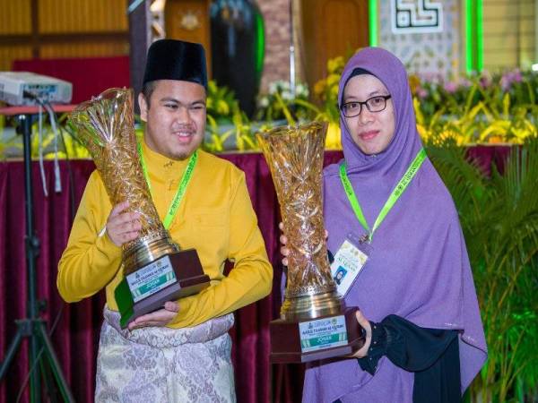 Muhammad Qayyim Nizar (kiri) dan Wan Sofea Aini bergambar bersama piala yang dimenangi mereka pada Majlis Pengurniaan Hadiah Tilawah dan Menghafaz Al-Quran Peringkat Negeri Kelantan Tahun 1441H/2020M di Dewan Kompleks Islam Darulnaim, Lundang malam tadi. - Foto Bernama