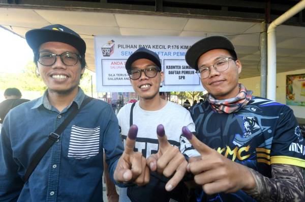 Kembar tiga (dari kiri) Zakaria Muhamud, Zaidi Muhamud dan Zaki Muhamud menunjukkan jarinya yang dicelup dakwat kekal selepas mengundi pada Pilihan Raya Kecil Parlimen Kimanis di Sekolah Kebangsaan Our Lady of Fatima (M) Kelatuan hari ini. - Foto: Bernama
