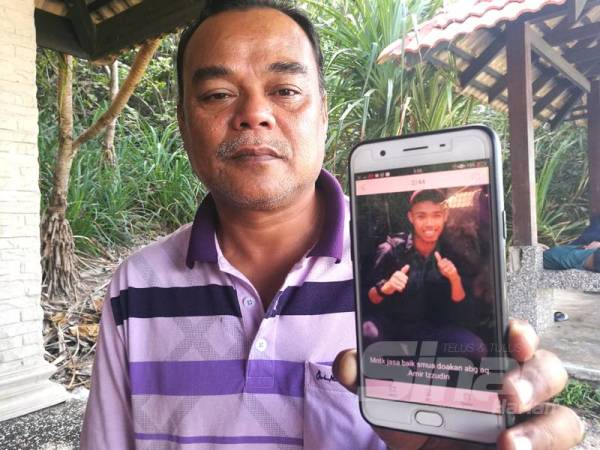 Zulkiflee menunjukkan gambar Mohamad Amir Izzudin di telefon bimbitnya.