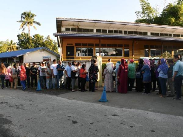 Orang ramai beratur bagi menunaikan tanggungjawab mengundi pada Pilihan Raya Kecil Parlimen Kimanis hari ini. - Foto Bernama