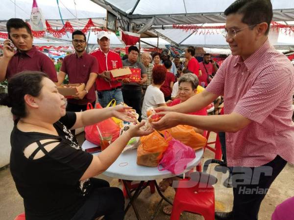 Mohamed Azmin mengedarkan buah limau pada program Walkabout Tahun Baru Cina DUN Bukit Antarabangsa dan Parlimen Ampang di Pasar Pekan Ampang pagi tadi.