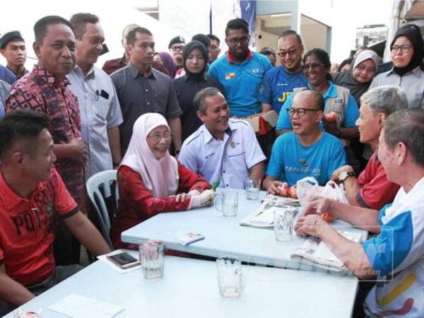 Dr Wan Azizah berbual bersama pengunjung di gerai makan pada Program Edaran Limau di Pasar Pagi Pandan Jaya dan Pasar Taman Muda, Ampang hari ini. - FOTO ZAHID IZZANI