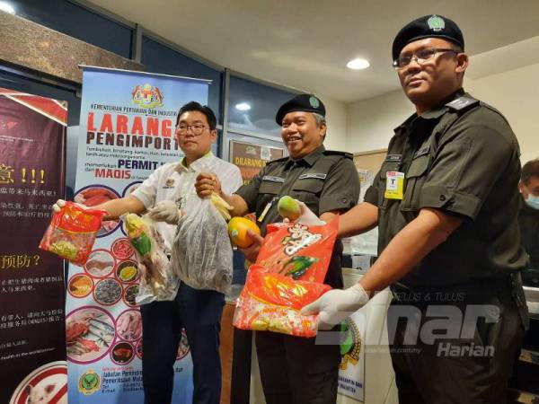 Tze Tzin (kiri) bersama Ketua Pengarah Maqis, Saiful Yazan Alwi (tengah) menunjukkan daging babi yang dirampas di LTAPP.