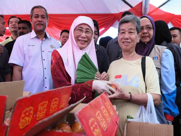 Dr Wan Azizah menyampaikan limau kepada sebahagian masyarakat Tionghoa yang bakal menyambut Tahun Baru Cina pada Program Edaran Limau di Pasar Pagi Taman Muda hari ini. - Foto Bernama