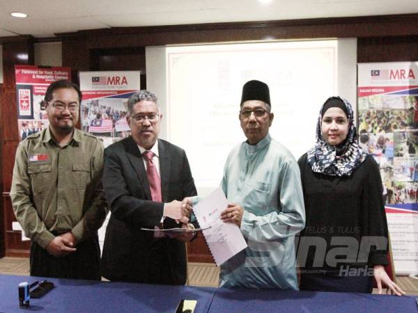 Yusop Khan (dua dari kanan) bertukar MoU yang ditandatangani bersama Mohd Daud (dua dari kiri) sambil diperhatikan oleh Zubida (kanan) dan Shahrizal Azwan di Mini Theater FIM, Kelana Jaya kelmarin. - FOTO ZAHID IZZANI