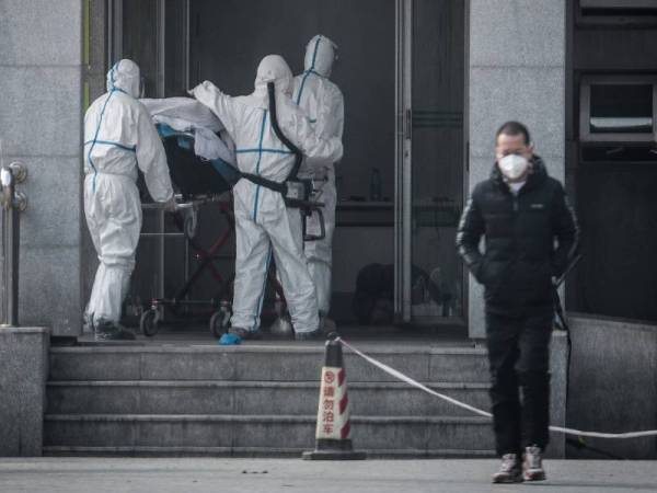 Kakitangan perubatan membawa seorang pesakit ke hospital Jinyintan yang memberi rawatan kepada individu dijangkiti virus korona baharu. - Foto: AFP