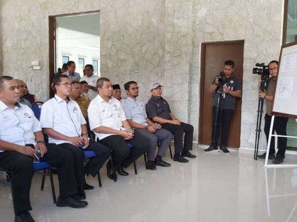 Salman (kiri) memberi taklimat kepada Dr Sahruddin (kanan) sempena lawatan rasmi ke daerah Kota Tinggi hari ini.