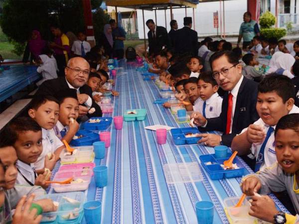 Azman ( tiga dari kanan, duduk) bersama murid SK Pekan Layang-Layang pada program penambahbaikan RMT di sini hari ini.