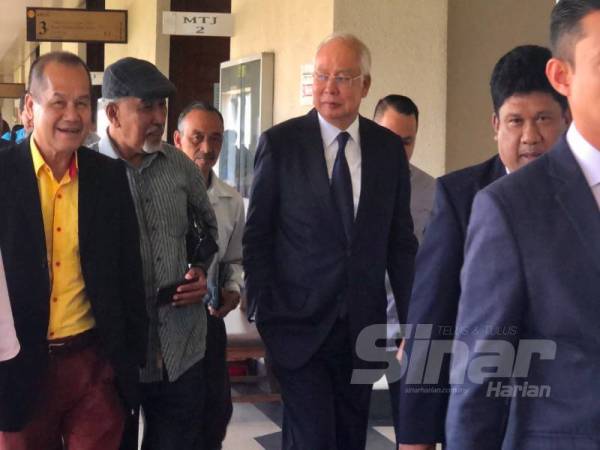 Najib (tiga dari kiri) beredar dari Mahkamah Tinggi Kuala Lumpur selepas perbicaraan kes SRC International Sdn Bhd semalam. 