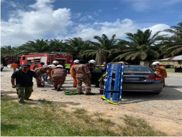 Anggota bomba membantu mengeluarkan mangsa kemalangan dekat Gugusan Adela petang tadi. - Foto ihsan bomba 