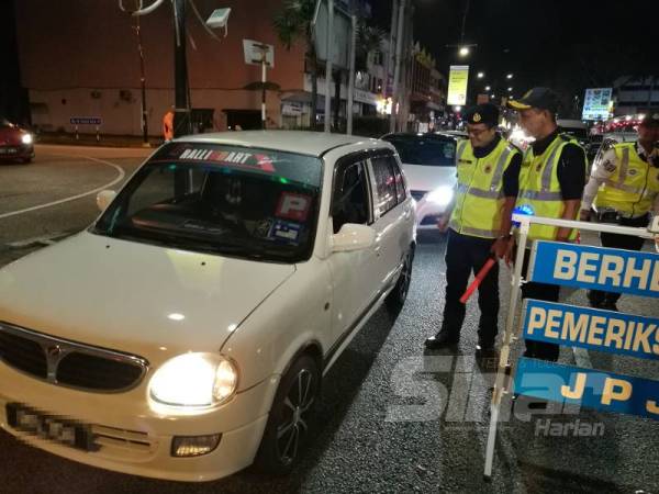 Muhammad melakukan pemeriksaan ke atas kenderaan dalam sekatan jalan pada Ops Khas Motosikal di Jalan Teluk Sisek di sini, malam tadi.
