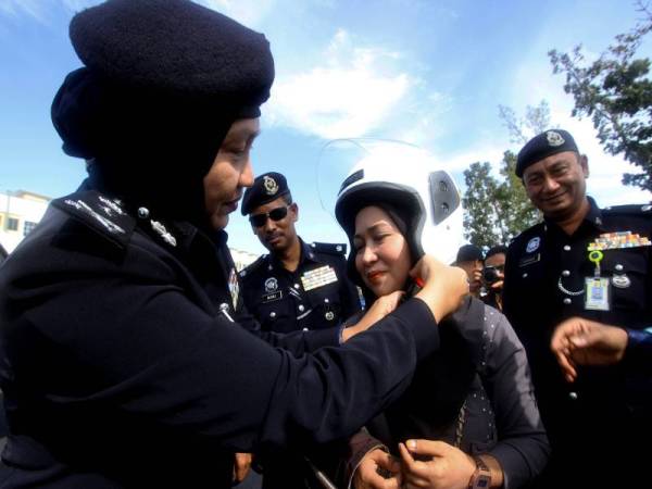 Ketua Polis Perlis Datuk Surina Saad (kiri) memakaikan topi keledar yang disumbangkan oleh Jabatan Keselamatan Jalan Raya (JKJR) kepada penunggang motosikal sempena pelancaran Op Selamat 16 Peringkat Negeri Perlis di hadapan Ibu Pejabat Polis Kontinjen (IPK) Perlis hari ini.
Foto: BERNAMA