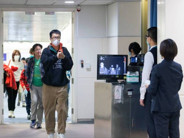 Pegawai CDC menggunakan pengimbas haba untuk memantau penumpang yang tiba dari wilayah Wuhan, China. - Foto AFP