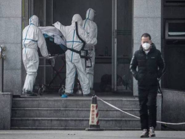 Kakitangan perubatan membawa seorang pesakit ke hospital Jinyintan yang memberi rawatan kepada individu dijangkiti virus korona baharu. - Foto: AFP