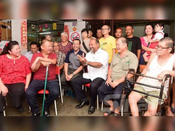 Gobind (duduk, tiga dari kanan) dan Hasnul (duduk, empat dari kanan) beramah mesra dengan penghuni Pusat Jagaan Orang Tua Wan Hing di Seri Kembangan kelmarin. - Foto Sinar Harian ROSLI TALIB