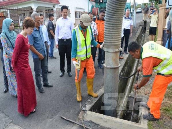 Al'Ashari (tengah) Nicole (kiri) dan Teo Kok Seong (tiga dari kiri) semasa melihat kerja-kerja pembersihan pekerja SWM Environment hari ini.