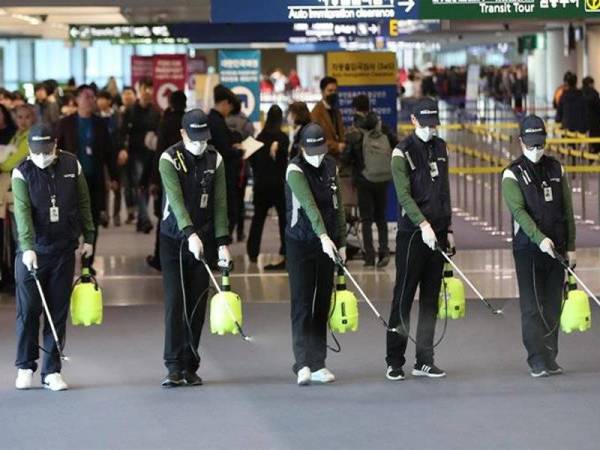 Pekerja kuarantin membuat semburan pembasmian kuman di Lapangan Terbang Antarabangsa Incheon di Korea Selatan selepas seorang wanita yang datang dari Wuhan didapati mempunyai koronavirus baharu. - Foto Yonhap