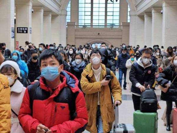 Pihak berkuasa turut mewajibkan pemakaian topeng muka di Wuhan. - Foto Agensi