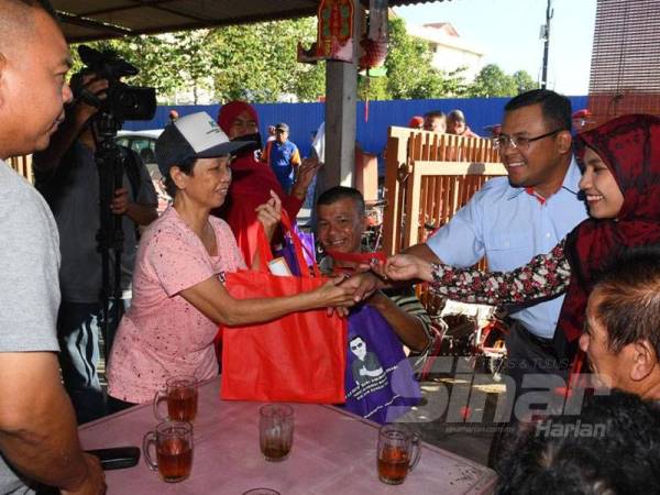 Amirudin (dua kanan) dan isteri, Masdiana Muhamad (kanan) menyantuni masyarakat Tiong Hua di Selayang Baru hari ini.