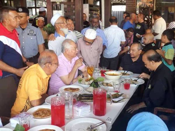 Najib (dua dari kiri) beramah mesra dengan orang ramai yang hadir program Santai Bossku Bersama,asyarakat Parlimen Pokok Sena di Restoran Gemilang Kitchen, Hutan Kampung di sini hari ini.