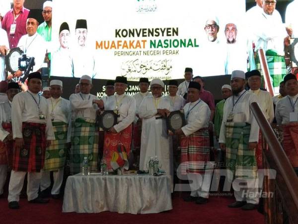 Ahmad Zahid (tiga dari kiri) menerima resolusi daripada Razman manakala Abdul Hadi (tiga dari kanan) menerima resolusi daripada Saarani pada Konvensyen Muafakat Nasional Negeri Perak di Kompleks UMNO Bahagian Bagan Datuk, Sungai Sumun di sini hari ini.
