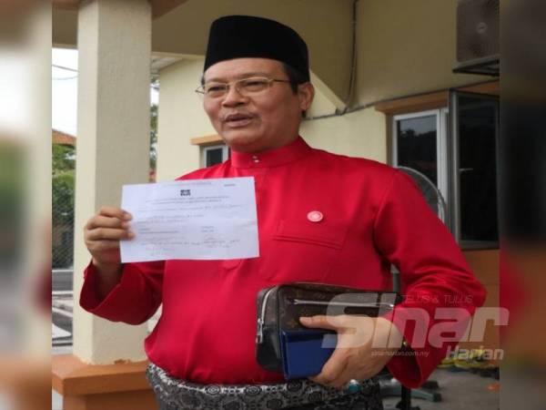 Zulkafperi menunjukkan slip pengesahan penerimaan pencalonan bagi jawatan Ketua Bahagian Bersatu Tanjong Karang di Balai Masyarakat Puncak Alam Fasa 2 pagi tadi.