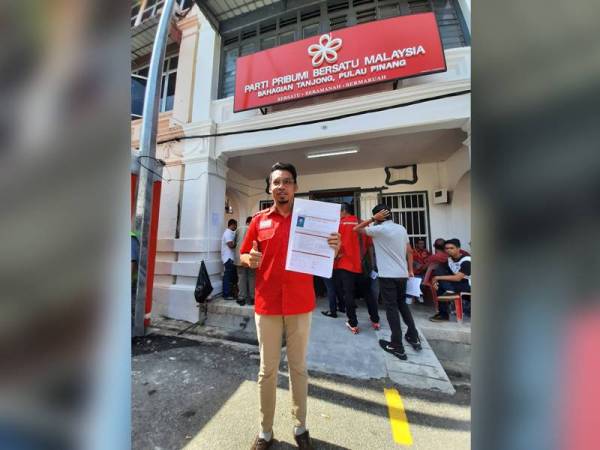 Razalif menunjukkan borang pencalonan di hadapan Pejabat Bersatu Bahagian Tanjong tadi.