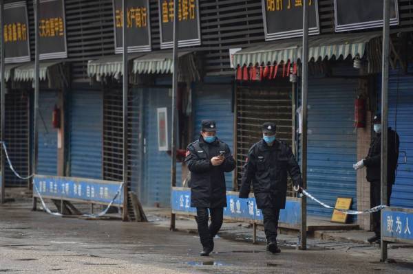 Pengawal keselamatan berkawal di luar Pasar Borong Makanan Laut Huanan di Wuhan. - Foto AFP