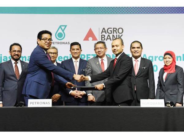 Mohamed Azmin dan Salahuddin menyaksikan pertukaran dokumen Kerjasama Strategik antara Petronas dan Agrobank: Program Memperkasakan B40. - Foto Bernama