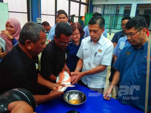 Munir (dua dari kanan) dan Azahari (kanan) melihat demonstrasi pembenihan ikan kelah di PPA Perlok semalam.