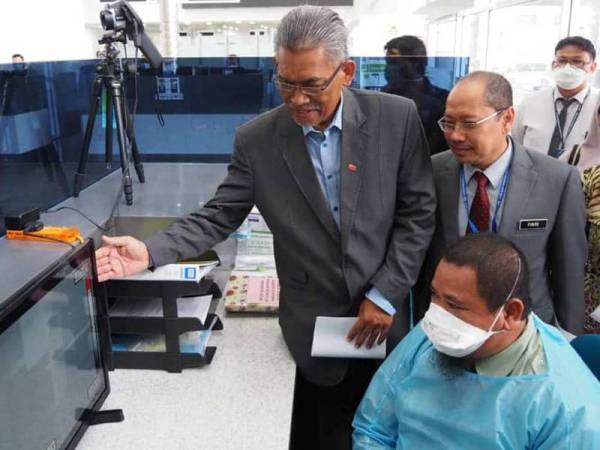 Dr Ismail (kiri) ketika meninjau proses saringan dan pemantauan kesihatan terhadap pengunjung yang memasuki sempadan negara di Kompleks Imigresen, Kastam dan Kuarantin Keselamatan (ICQS), Bukit Kayu Hitam, Isnin lalu.