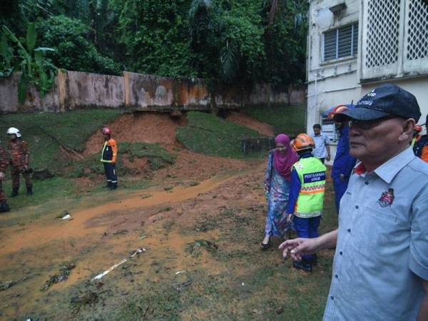 Nor Hisham (kanan) meninjau keadaan tanah runtuh di SMK Convent Bukit Nanas.