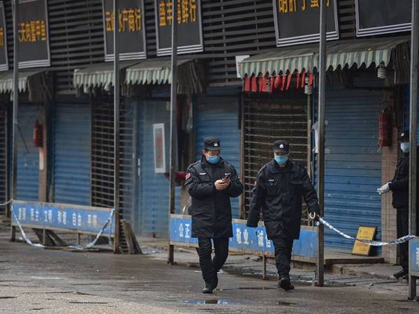 Pengawal keselamatan berkawal di luar Pasar Borong Makanan Laut Huanan di Wuhan. - Foto AFP