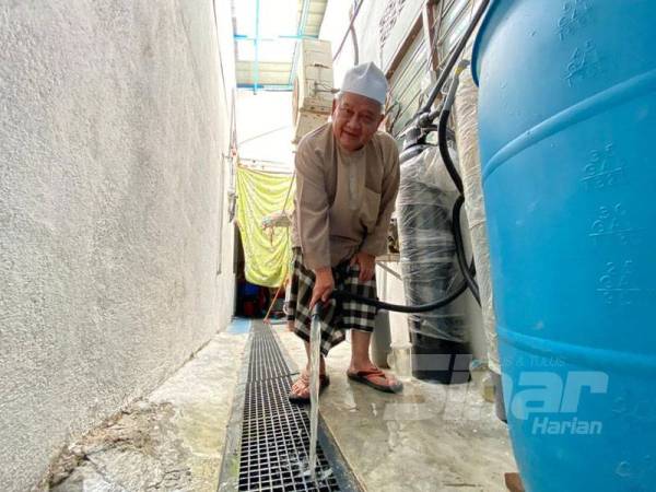 Baharom menunjukkan air disalurkan dari telaga tiub yang dibina.