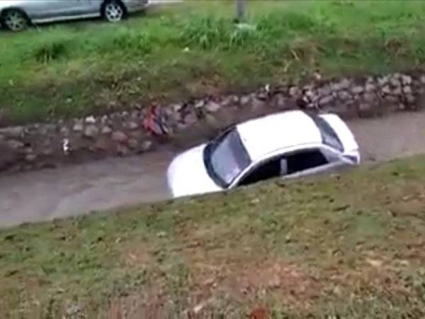 Kereta mangsa yang terbabas dan hanyut di dalam longkang.