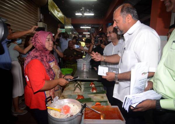 Gobind Singh Deo memberi penerangan kepada peniaga serta mengedarkan risalah mengenai pencegahan jangkitan koronavirus pada Program 'Info On Wheels' di Astaka Lorong Kulit hari ini. -Foto Bernama