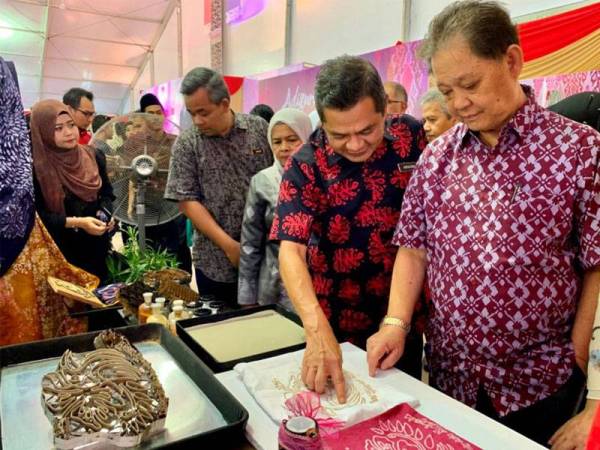 Mohamaddin (kanan) bersama Ibrahim melihat carok batik yang dihasilkan di festival tersebut semalam.