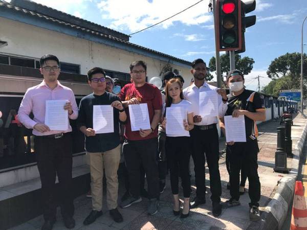 Chuan How (kiri) bersama ahli DAPSY membuat laporan polis terhadap Musa di IPD Ipoh hari ini.