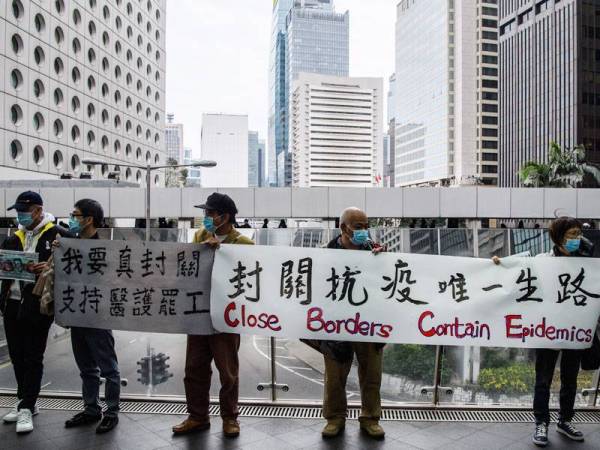 Kumpulan penunjuk perasaan membawa kain rentang ketika flash mob bagi menuntut kerajaan Hong Kong menutup sempadan yang menghubungkan dengan China. - FOTO: AFP