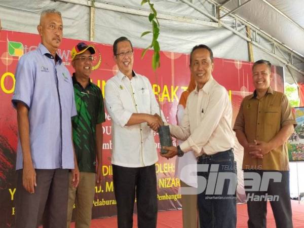 Mohammad Nizar (tengah) menyampaikan anak pokok pada Program Ekonomi Komuniti Perak Tengah di Kompleks Desa Warisan IGROW Pulau Tiga, Kampung Gajah di sini hari ini.