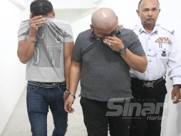 Arif (kiri) dan Ahmad Sufian dikawal polis keluar dari mahkamah menuju ke lokap selepas dijatuhi hukuman akibat berlumba bulan lalu.