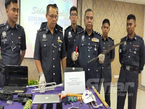 Osman (tiga dari kanan) menunjukkan parang dan pisau yang dirampas dari Geng Hafiz Axia pada sidang akhbar di IPD Taiping semalam.