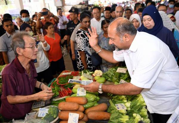 Gobind (kanan) kelihatan memberi penerangan mengenai jangkitan koronavirus kepada para peniaga Pasar Besar Seremban pada Program 'Info On Wheel' hari ini. -Foto Bernama