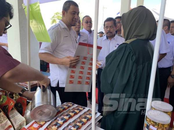 Dr Sahruddin (kiri) beramah mesra bersama seorang usahawan yang menyertai Program Empower ECER Mersing.