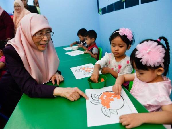 Dr Wan Azizah (kiri) beramah mesra bersama kanak-kanak ketika membuat lawatan di sekitar taska sempena Majlis Perasmian Taska Parlimen Malaysia hari ini. - Foto Bernama