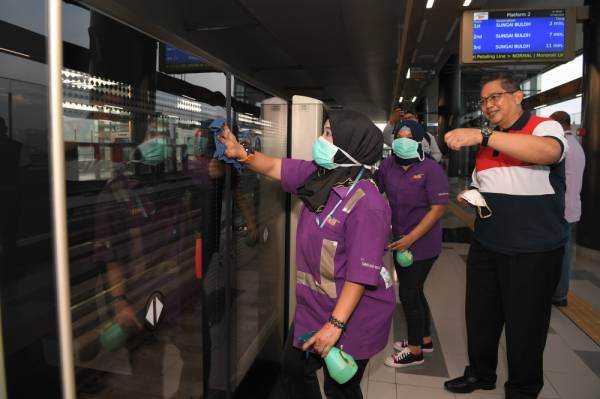 Pekerja Pembersihan MRT Bandar Tun Hussein Onn Intan Permata Sari (kiri) bersama rakannya membersihkan fasiliti di sekitar MRT ini pada Pemeriksaan Kesihatan Kapten Bas Rapid KL bagi mencegah penyebaran novel koronavirus 2019 (2019-nCoV) di MRT Bandar Tun Hussein Onn hari ini. -Foto Bernama