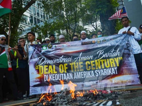 Patung Trump bersama bendera Amerika Syarikat dan Israel dibakar pada Himpunan Aman Bantah Deal of The Century di hadapan Kedutaan Amerika Syarikat hari ini. - Foto SHARIFUDIN ABDUL RAHIM