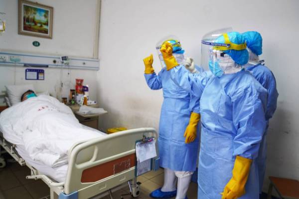 Anggota perubatan melawat salah seorang pesakit yang dijangkiti koronavirus di sebuah hospital di Zouping di timur wilayah Shandong, China. - Foto AFP