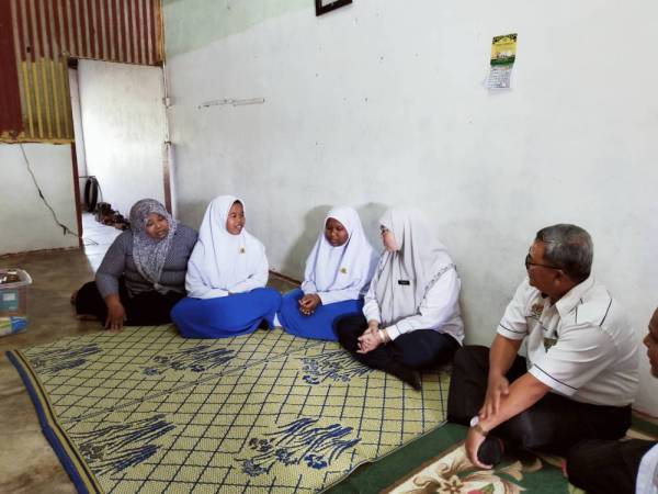 Habibah (dua dari kanan) bertanya khabar dua beradik yang diziarahinya pada Program Ziarah Cakna Peringkat Kebangsaan Tahun 2020, di Kampung Pering di sini hari ini.